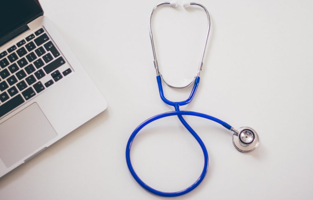 Stethoscope next to a laptop. Medication assisted treatment.