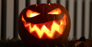 A pumpkin carved into a jak o'lantern with a scary smile.