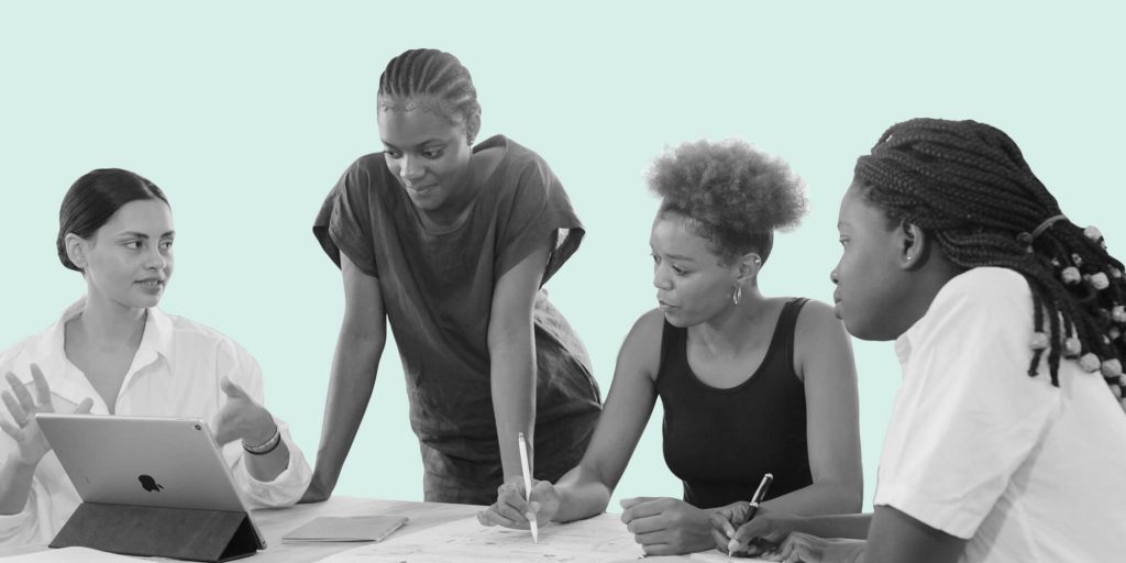 A group of four young Black women collaborating around a table. Mental health and recovery resources for BIPOC