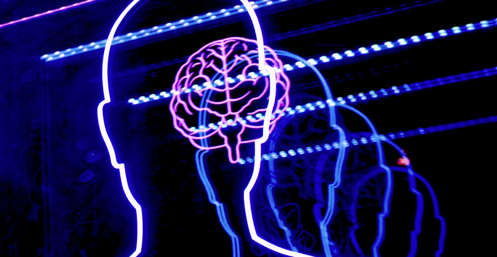 Glowing lights outline a human body. In the head is a glowing line-art brain.