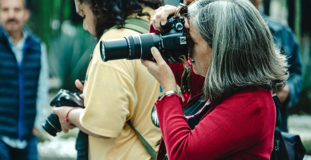 Several photographers with cameras up to thier faces as they take pictures