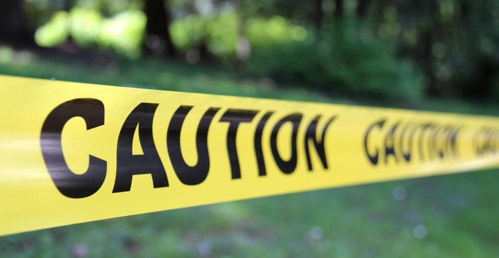 Yellow CAUTION tape blocking an outdoor area