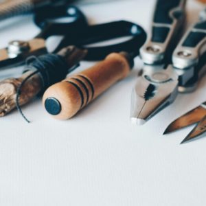 A line of hand tools lying on a white background