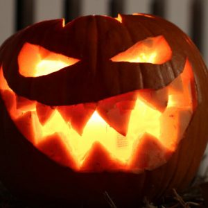 A pumpkin carved into a jak o'lantern with a scary smile.